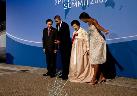 Obama looks at his shoes before playing hopscotch